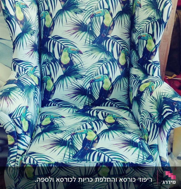 כורסה מרופדת בבד עם דוגמת תוכים ועלים